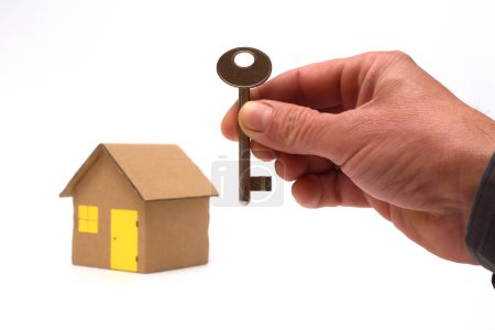 Foto de Agente inmobiliario con modelo de casa y llave sobre blanco - Imagen libre de derechos