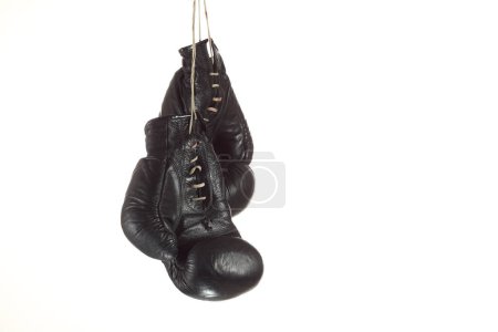 Foto de Guantes de boxeo negro colgando sobre un fondo blanco - Imagen libre de derechos