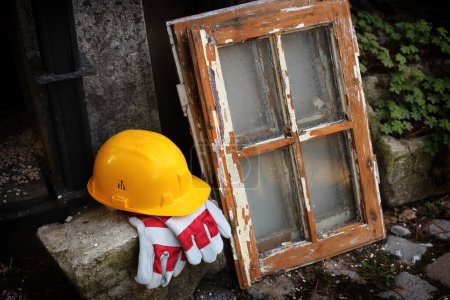 Photo for Safety first yellow helmet and old window - Royalty Free Image