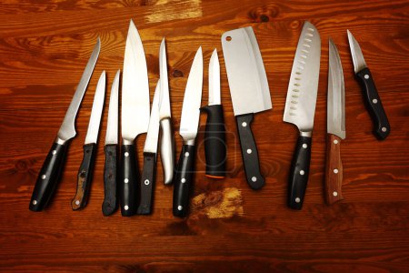 different kitchen knifes over wooden table