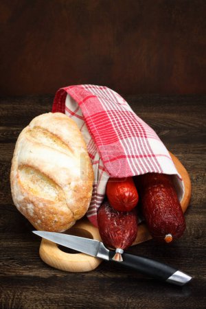 Foto de Un poco de salami y pan en una tabla de la cocina - Imagen libre de derechos