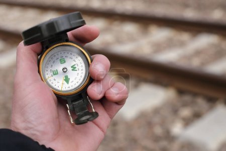 Téléchargez les photos : Boussole en main sur ligne de chemin de fer - en image libre de droit