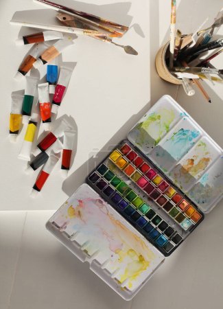 Photo for Empty copy space canvas, watercolor and acrylic paints in tubes, palette knife. Flat lay, top view. Creative mess in the artistic workshop. - Royalty Free Image