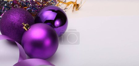 Foto de Close-up Violeta brillo textura nácar y brillo Feliz bola de Navidad, cinta sobre fondo horizontal beige. - Imagen libre de derechos