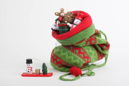 Foto de Bolso de punto de Navidad con pequeño juguete de regalo de Navidad decorativo de madera. - Imagen libre de derechos