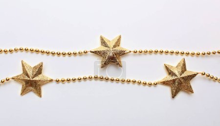 Foto de Guirnalda estrella de oro marco en beige claro espacio de copia vacío fondo horizontal. - Imagen libre de derechos