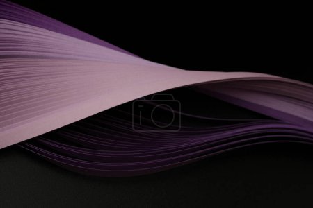 Foto de Color violeta tira de papel ondulado sobre negro. Fondo de textura abstracta. - Imagen libre de derechos