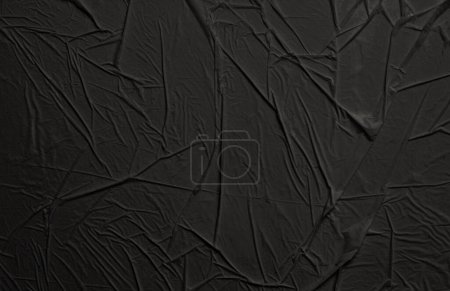 Empty crumpled wet black paper blank texture copy space wall horizontal background.