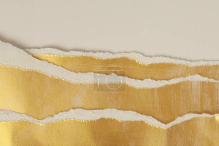 Foto de Oro desgarrado pedazos vacíos de papel de textura sobre fondo de espacio de copia beige claro. - Imagen libre de derechos