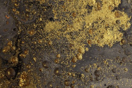 Foto de Flujo de arte vierta aceite y acrílico color pintura blot pared. Fondo abstracto de textura negra y dorada. - Imagen libre de derechos