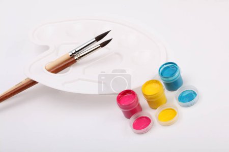 Photo for Acrylic paints in boxes, brushes and white palette. - Royalty Free Image