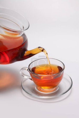 Téléchargez les photos : Tasse à thé et théière en verre sur fond vertical léger. - en image libre de droit
