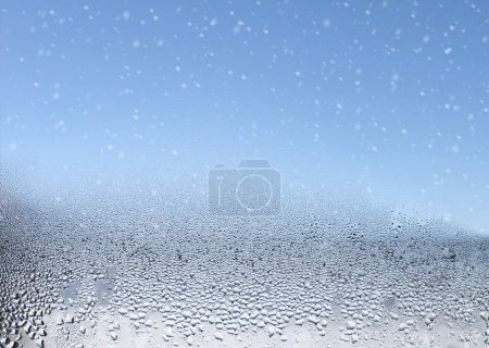 Photo for Water drops and snow on the wet window glass. Abstract background. - Royalty Free Image