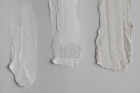 Téléchargez les photos : Oil and acrylic smear relief brushstroke blot on gray wall. Abstract texture canvas painting background. - en image libre de droit