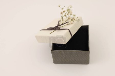 Foto de Craft gift box with flower on light beige background. Copy space minimalism style template background. - Imagen libre de derechos