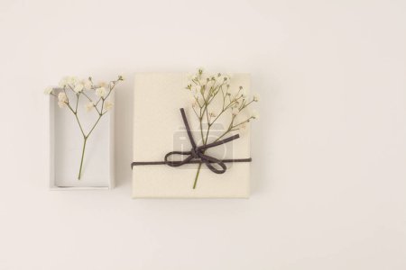 Photo for Craft gift boxes with flower  on light beige background. Copy space minimalism style template background. Flat lay, top view - Royalty Free Image