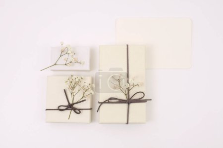 Photo for Craft gift boxes with flower wreath on light beige background. Copy space minimalism style template background. Flat lay, top view - Royalty Free Image