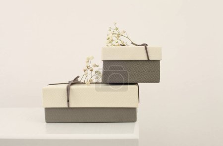 Foto de Craft gift boxes with flower on light beige background. Copy space minimalism style template background. - Imagen libre de derechos