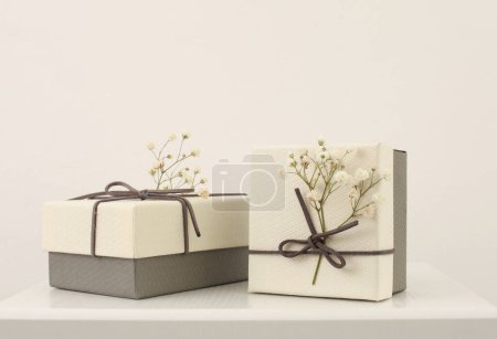 Foto de Craft gift boxes with flower on light beige background. Copy space minimalism style template background. - Imagen libre de derechos