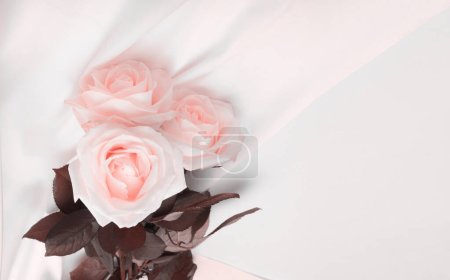Téléchargez les photos : Wave fabric silk with beige pink rose flower bouquet. Abstract texture horizontal copy space background. - en image libre de droit