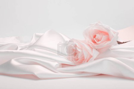 Foto de Tela ondulada de seda con ramo de flores de color rosa beige. Textura abstracta horizontal copia espacio fondo. - Imagen libre de derechos