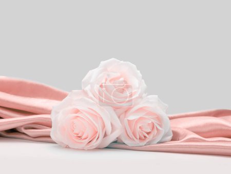 Téléchargez les photos : Nacre Wave tissu soie avec bouquet de fleurs rose beige rose. Texture abstraite espace de copie horizontal arrière-plan. - en image libre de droit