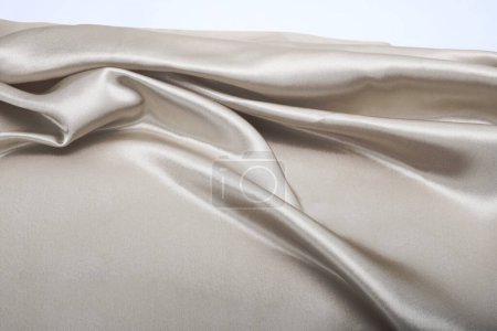 Téléchargez les photos : Tissu beige gris perle vague en soie. Texture abstraite espace de copie horizontal arrière-plan. - en image libre de droit