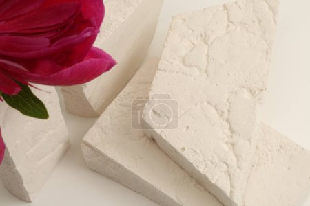 Foto de Flor pétalo rosa y piedras vacías plataforma podio sobre fondo beige. Escena de presentación mínima del producto. - Imagen libre de derechos