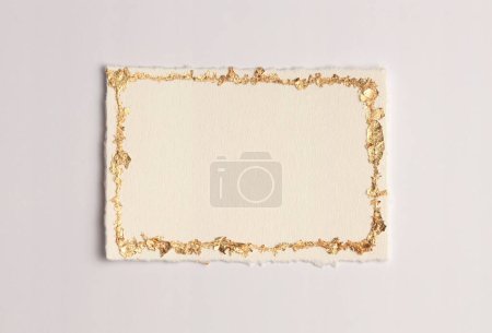 Gold (bronze) glitter empty canvas frame on beige gray paper background. Abstract copy space texture.