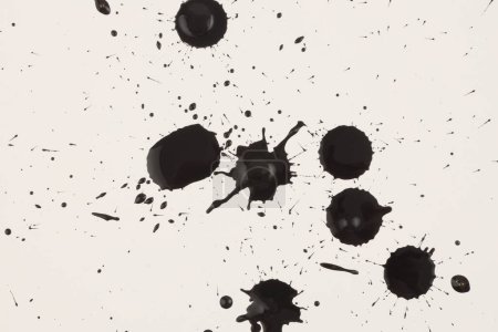 Photo for Black ink and watercolor drop splash blots on light beige paper background. - Royalty Free Image