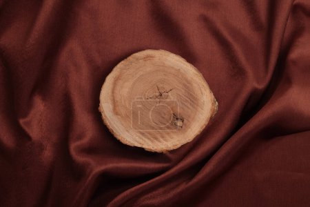 Téléchargez les photos : Podium plateforme souche en bois sur fond de tissu de soie marron. Scène de présentation minimale du produit d'affichage vide. - en image libre de droit