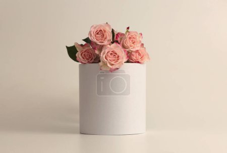 Téléchargez les photos : Bouquet de fleurs de rose sur podium blanc. Fond beige clair. Scène de présentation minimale du produit d'affichage vide. - en image libre de droit