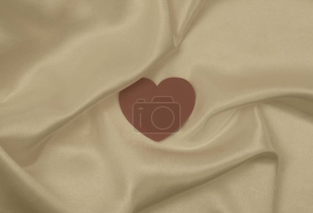 Photo for Beige brown pearl wave silk fabric with heart frame card. Abstract smoke texture copy space background. - Royalty Free Image