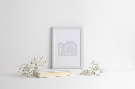 Foto de Mesa de oficina (estante) con marco vacío y flores. Copiar espacio creativo Ligt beige neutral espacio de trabajo. - Imagen libre de derechos