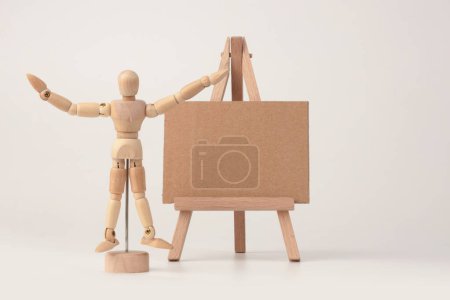 Foto de Maniquí de madera y pequeño caballete de madera. Arte Fondo beige claro. - Imagen libre de derechos