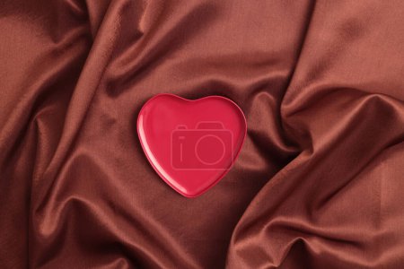 Foto de Corazón rojo vacío marco podiun. Abstracto marrón perla onda seda tela textura fondo. - Imagen libre de derechos