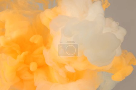Téléchargez les photos : Fond de fumée abstrait. Encre taches de couleurs dans l'eau. Jaune, blanc, beige. - en image libre de droit