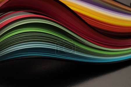 Foto de Color arco iris tira onda línea de papel en negro. Fondo de textura abstracta. - Imagen libre de derechos
