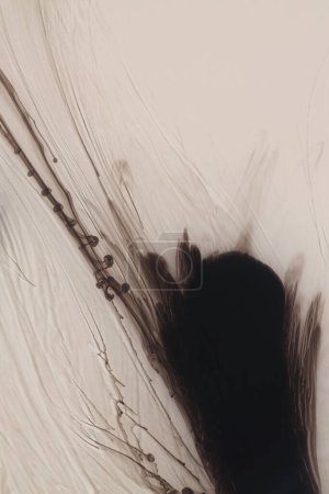 Foto de Tinta negra y acuarela vierten color de flujo sobre fondo de papel beige húmedo. - Imagen libre de derechos