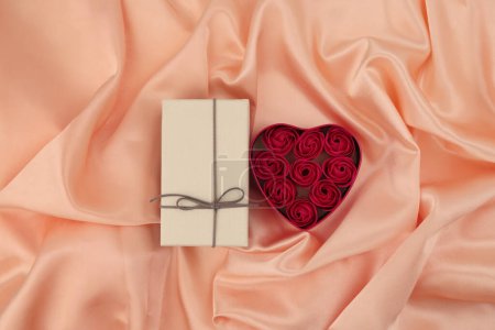 Photo for Heart frame gift box with rose flowers. Abstract Beige pink pearl wave silk fabric texture background. - Royalty Free Image