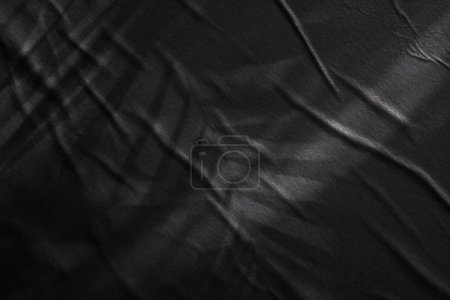 Foto de Papel húmedo arrugado negro textura en blanco espacio de copia luz y sombra pared de fondo. - Imagen libre de derechos