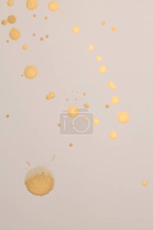 Foto de Gold, glitter Ink watercolor drop blot on beige paper texture background. - Imagen libre de derechos