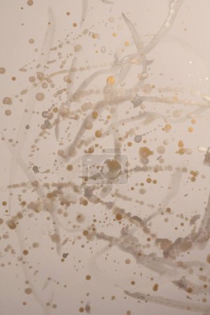 Photo for Gold, silver glitter Ink watercolor drop blot on beige paper texture background. - Royalty Free Image