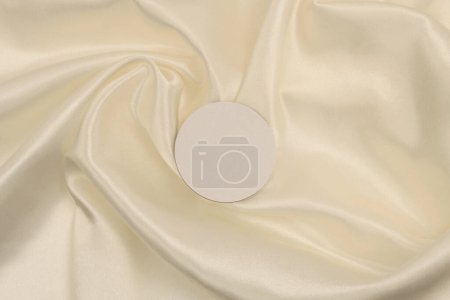 Téléchargez les photos : Cercle toile papier cadre étiquette sur nacre beige, fond tissu de soie. Texture abstraite de l'espace de copie. - en image libre de droit