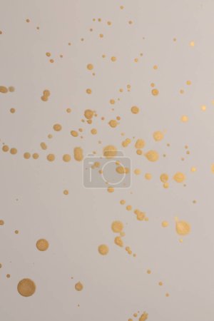 Foto de Oro, brillo Tinta acuarela gota mancha sobre fondo de textura de papel beige. - Imagen libre de derechos