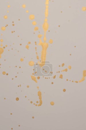 Téléchargez les photos : Or paillettes encre aquarelle goutte blot sur fond texture papier beige. - en image libre de droit