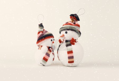 Téléchargez les photos : Deux petits jouets bonhomme de neige sur beige. Vintage style rétro fond de neige. - en image libre de droit