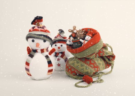 Téléchargez les photos : Sac à tricoter de Noël, bonhomme de neige avec petits jouets décoratifs de Noël. Vintage style rétro fond de neige. - en image libre de droit