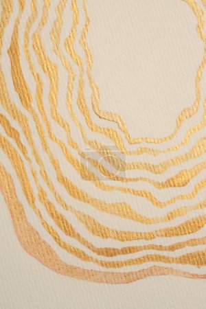 Foto de Tinta de brillo de nácar de oro mancha de línea de onda de acuarela en fondo de textura de papel de grano beige. - Imagen libre de derechos