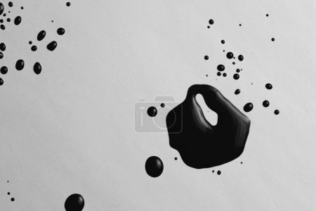 Téléchargez les photos : Encre aquarelle flux blot gouttes éclaboussure couleur noire tache sur fond de texture de papier gris. - en image libre de droit